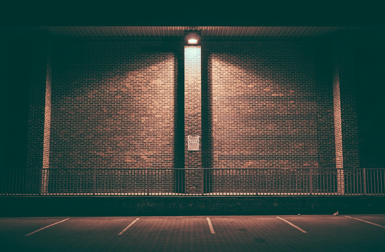 brick wall, empty, lighted, night, parking area, parking slot, parking spots, parking lot, steel railing, brick wall, brick wall, brick wall, brick wall, brick wall, parking lot, parking lot